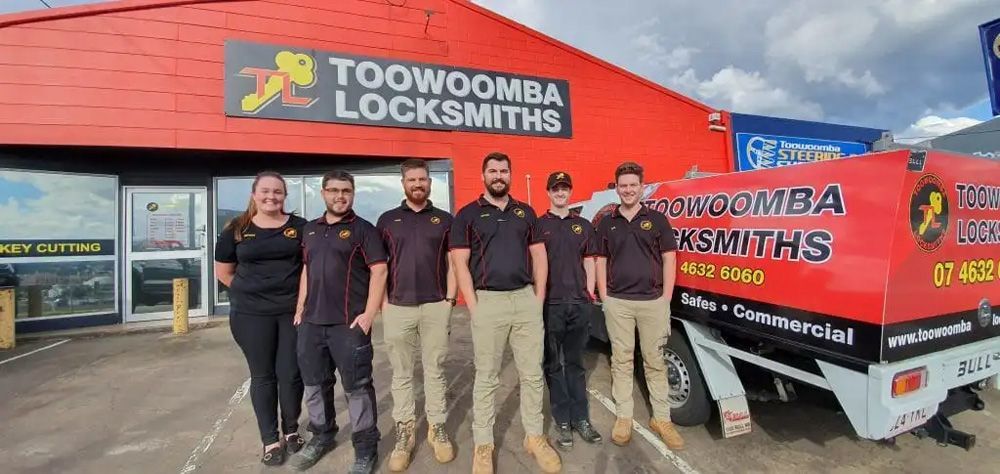 Group of People Are Posing for A Picture in Front of A Locksmith Shop — Toowoomba Locksmiths in Toowoomba City, QLD