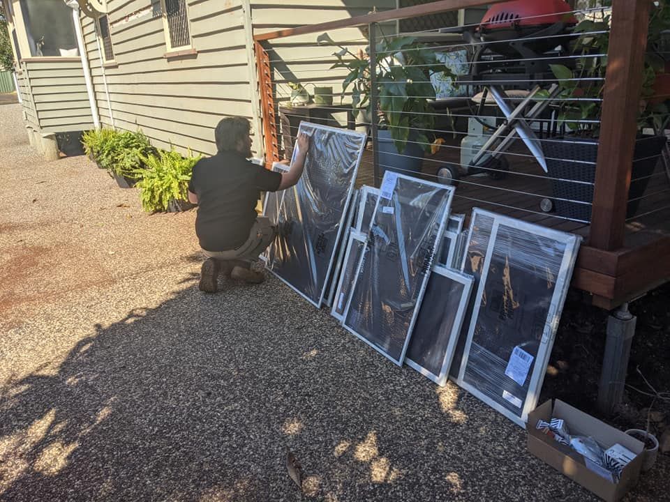 A Man Is Kneeling Down Next to A Bunch of Pictures — Toowoomba Locksmiths in Warwick, QLD