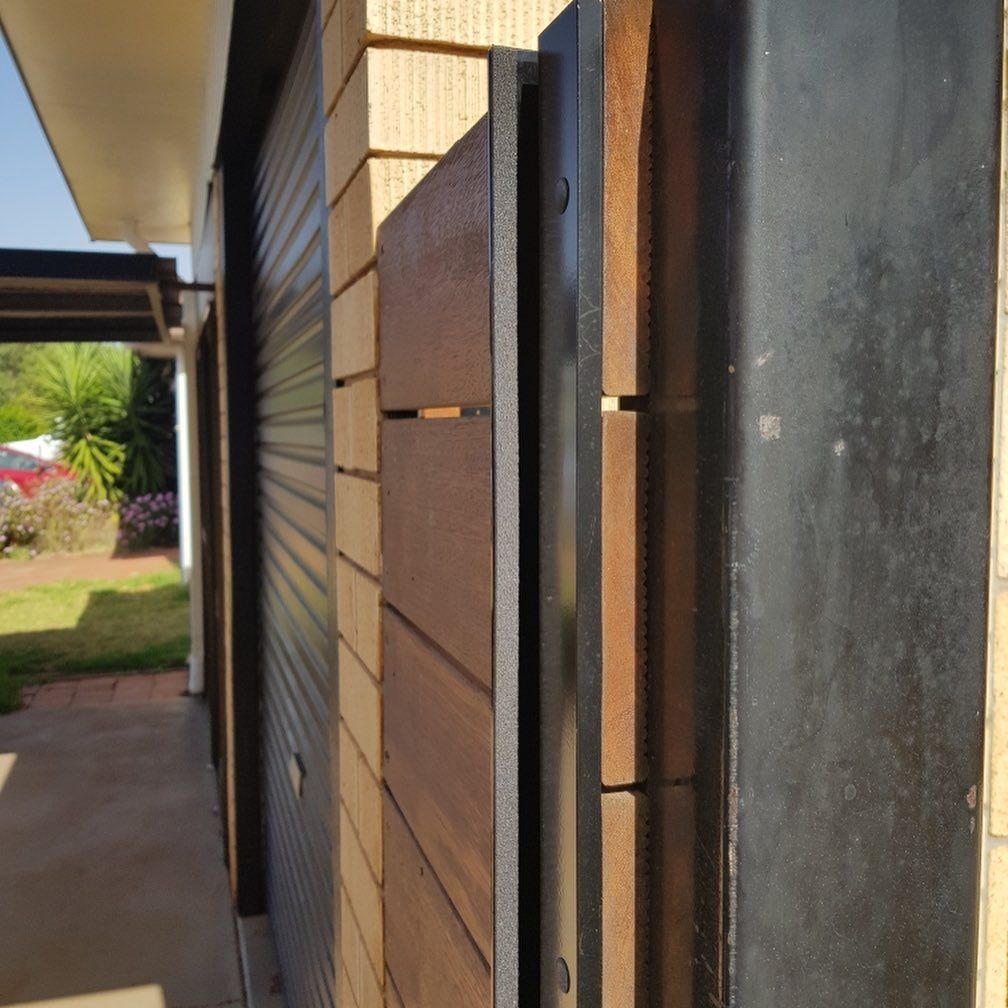 A Brick Building with A Wooden Fence — Toowoomba Locksmiths in Gatton, QLD