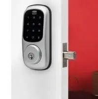 Smart Lock Is Mounted on A White Door Next to A Red Wall — Toowoomba Locksmiths in Toowoomba City, QLD