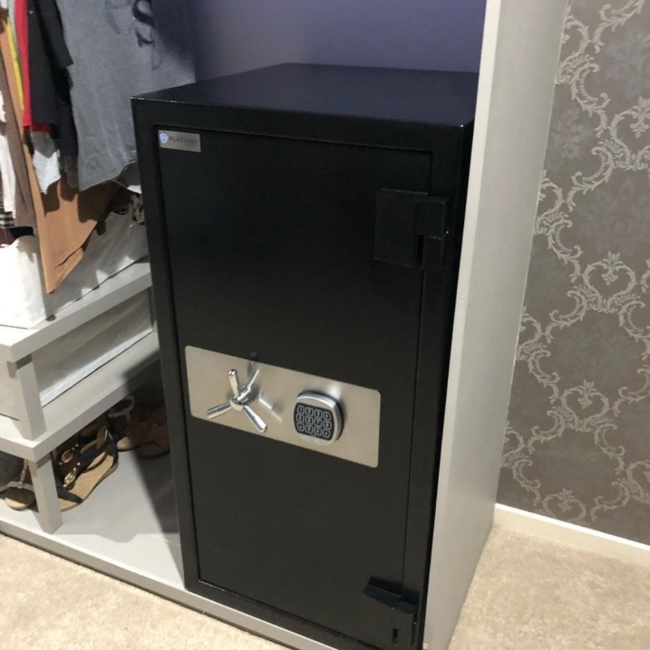 A Black Safe Is Sitting in A Closet Next to A Clothes Rack — Toowoomba Locksmiths in Toowoomba City, QLD