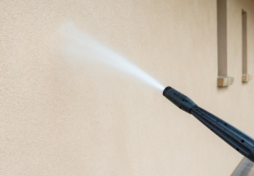 Removing graffiti from a wall.