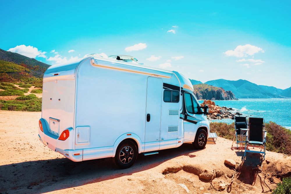 A White Rv Is Parked On A Dirt Road Next To The Ocean — Great Lakes Caravans In Forster, NSW
