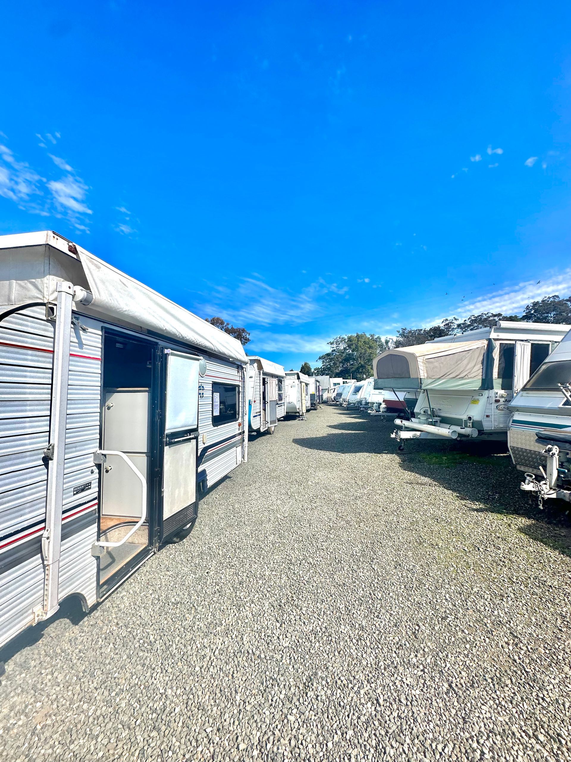 A White And Purple RV Is Parked In A Parking Lot — Great Lakes Caravans In Nabiac, NSW