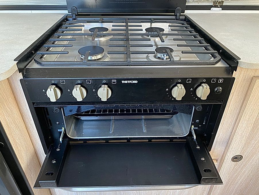A Gas Stove With The Oven Open In A Kitchen — Great Lakes Caravans In Nabiac, NSW