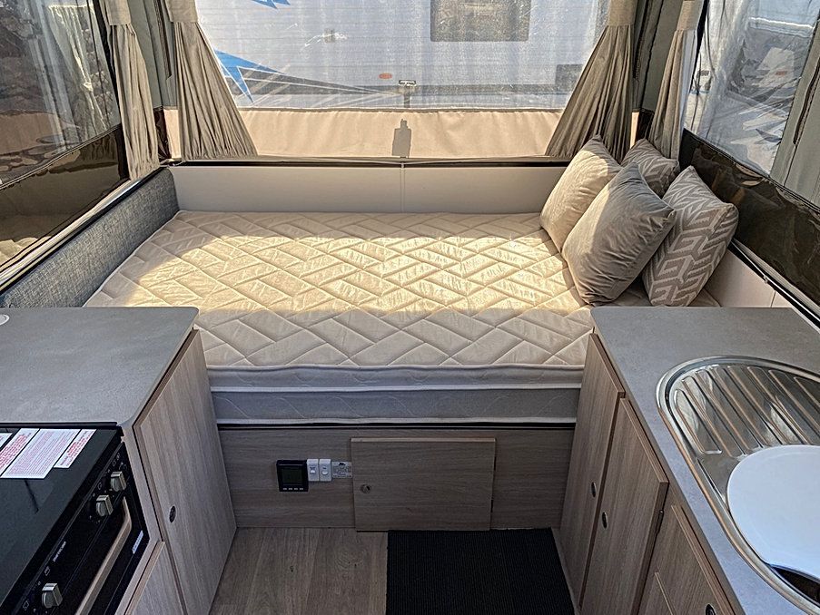 The Inside Of A Camper With A Bed And A Kitchen — Great Lakes Caravans In Nabiac, NSW