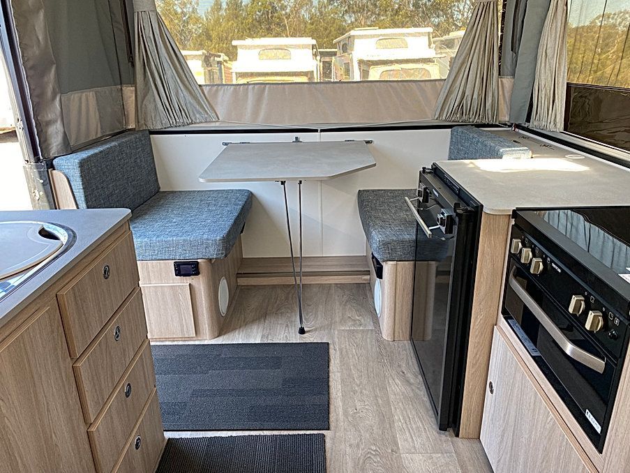 The Inside Of A Camper With A Table And A Stove — Great Lakes Caravans In Nabiac, NSW