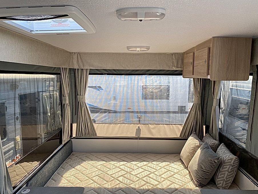 The Inside Of A Camper With A Bed And A Table — Great Lakes Caravans In Nabiac, NSW