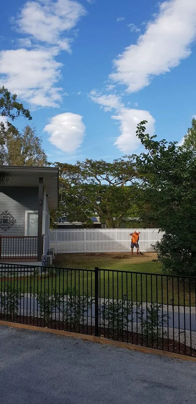 Residential Backyard With a White Fence, Orange Fire Hydrant — Barlows Tree Services in Rockhampton, QLD