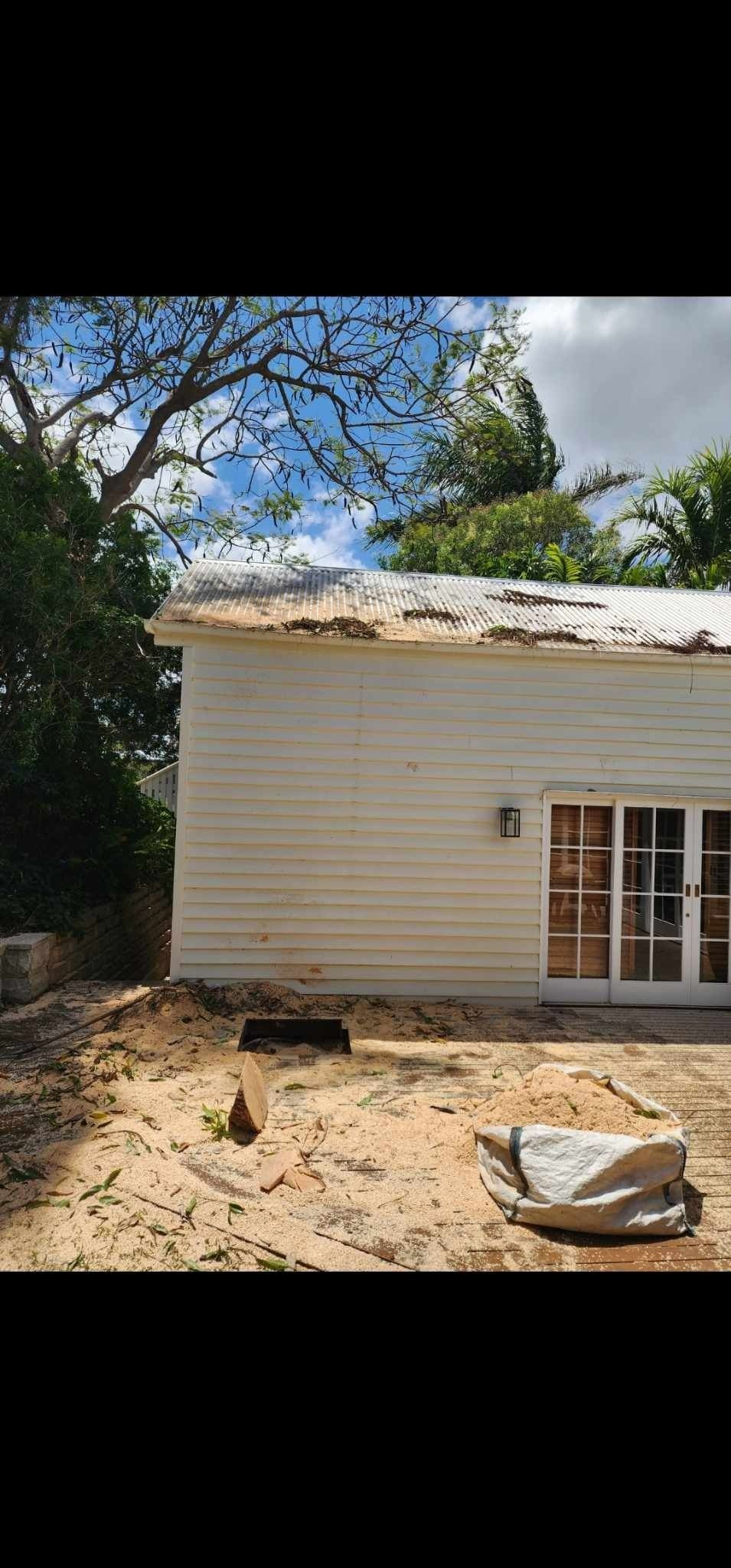 Damaged White House With Trees Nearby, and Debris in a Dirt Yard — Barlows Tree Services in Rockhampton, QLD