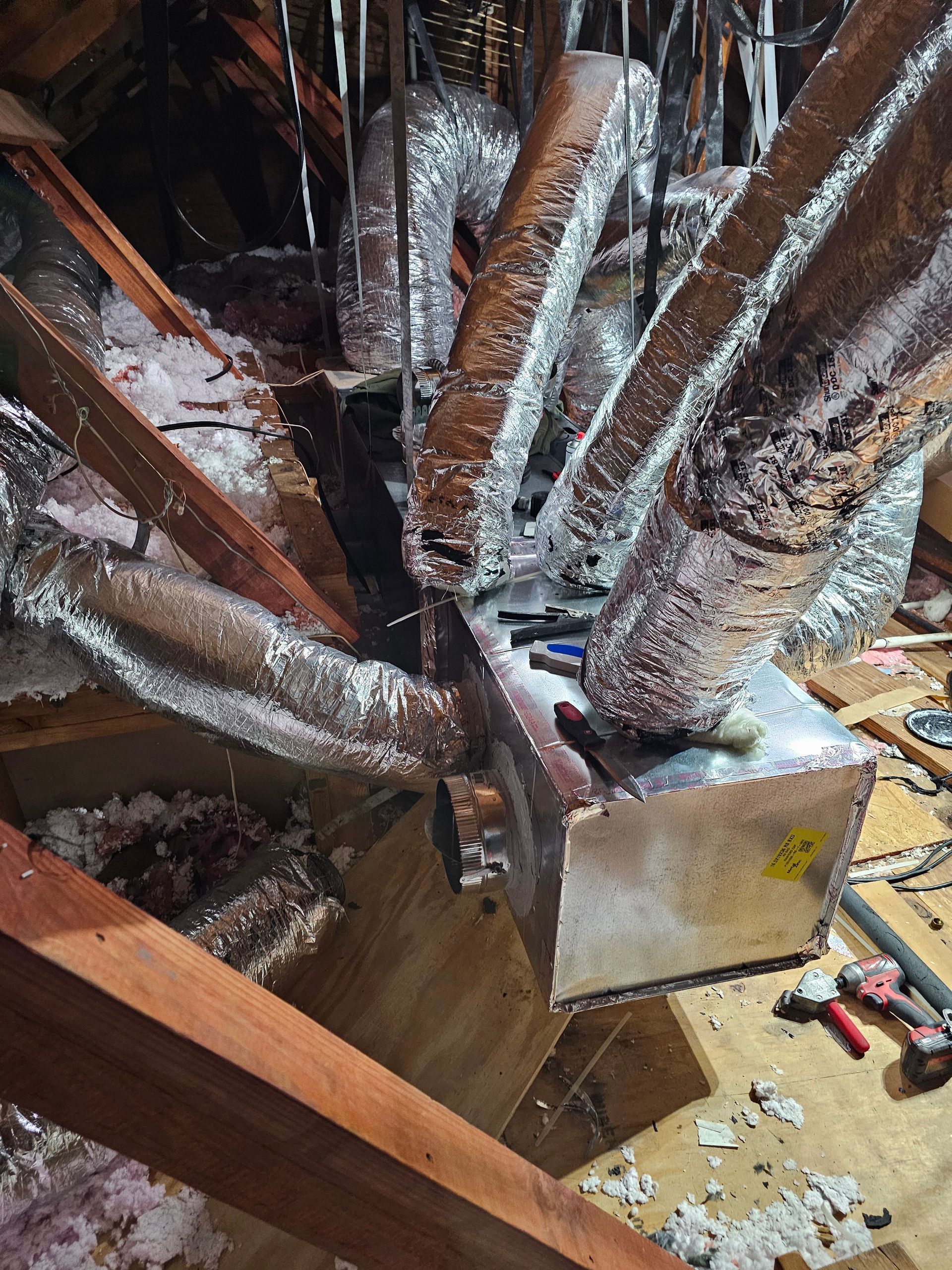 A bunch of aluminum ducts are sitting on top of a wooden table.