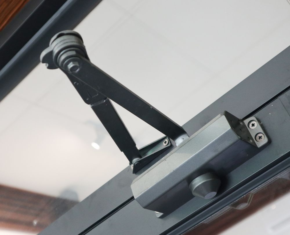 Black door closer mechanism on a glass door.