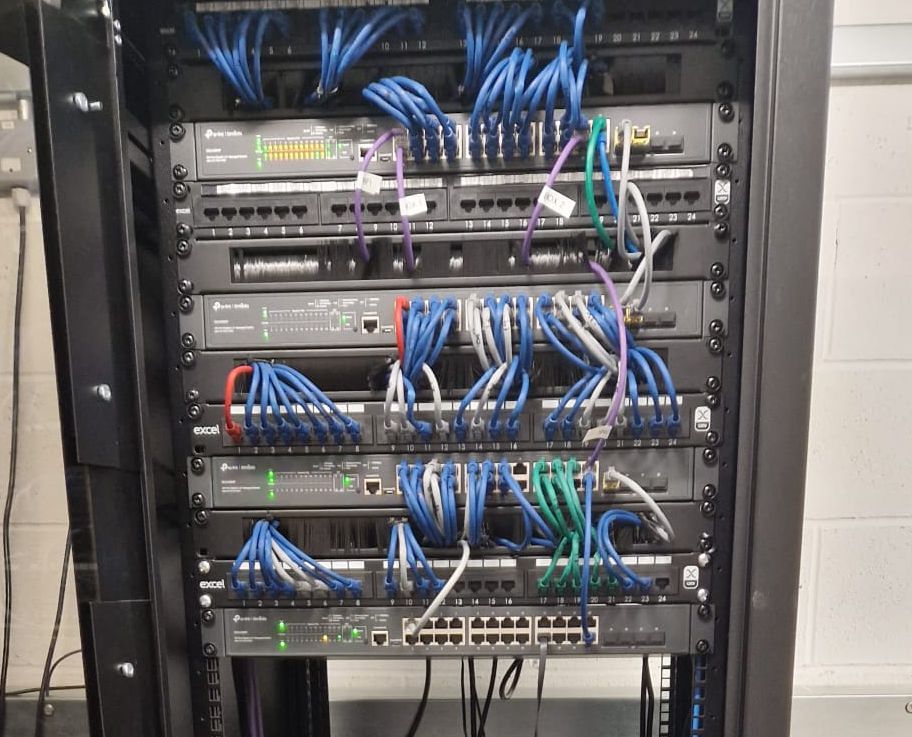 A server rack filled with network equipment and numerous blue and white network cables.