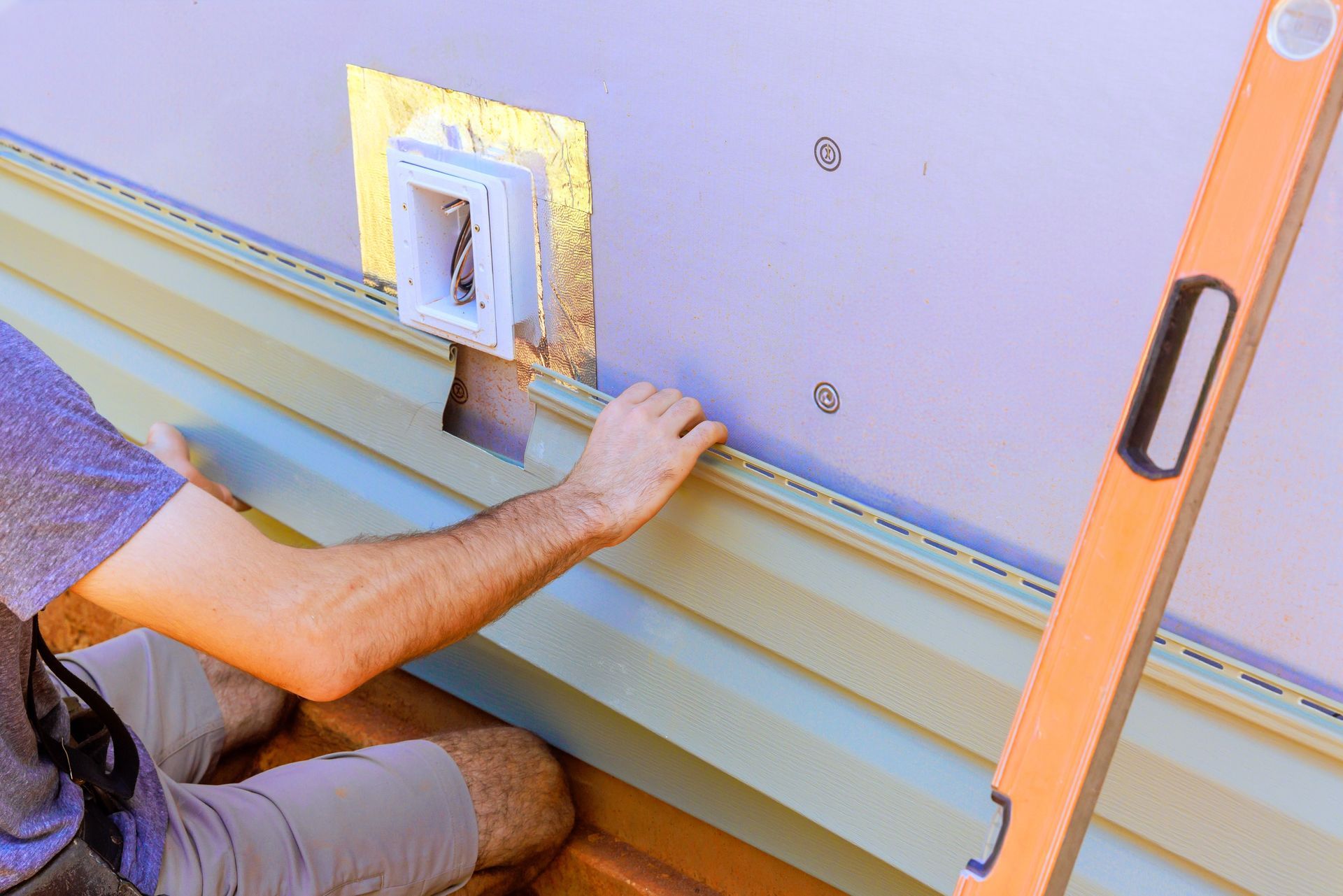 Woman in straw hat smiles, holding wine glass near a lake.