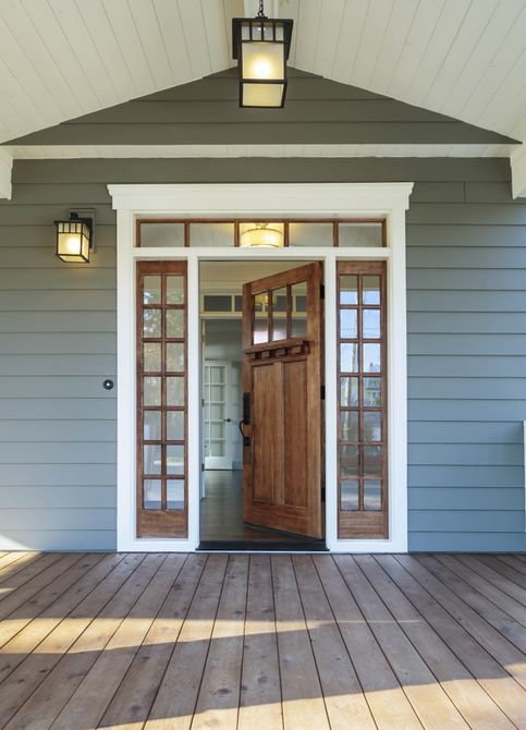 Front porch of blue-gray house with open front door