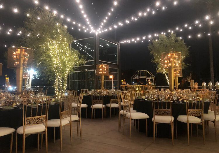 Tables and chairs are set up for a wedding reception at night