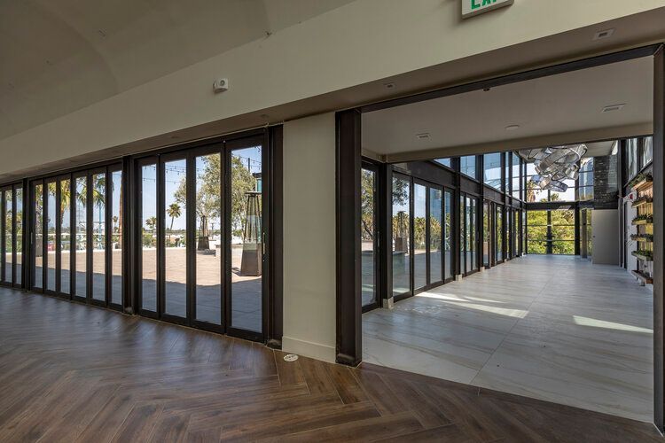 A large room with a lot of windows and a wooden floor.