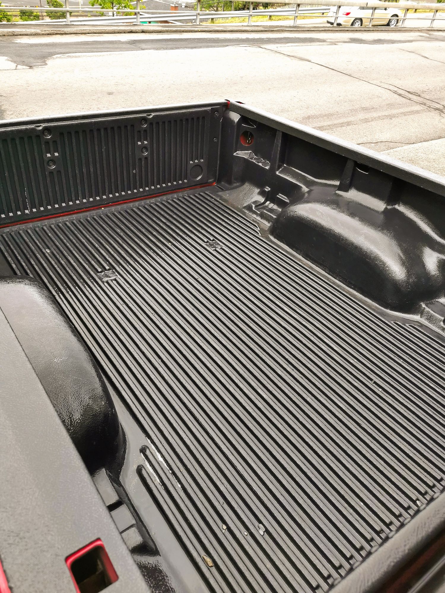 The back of a truck with a rubber mat on it.