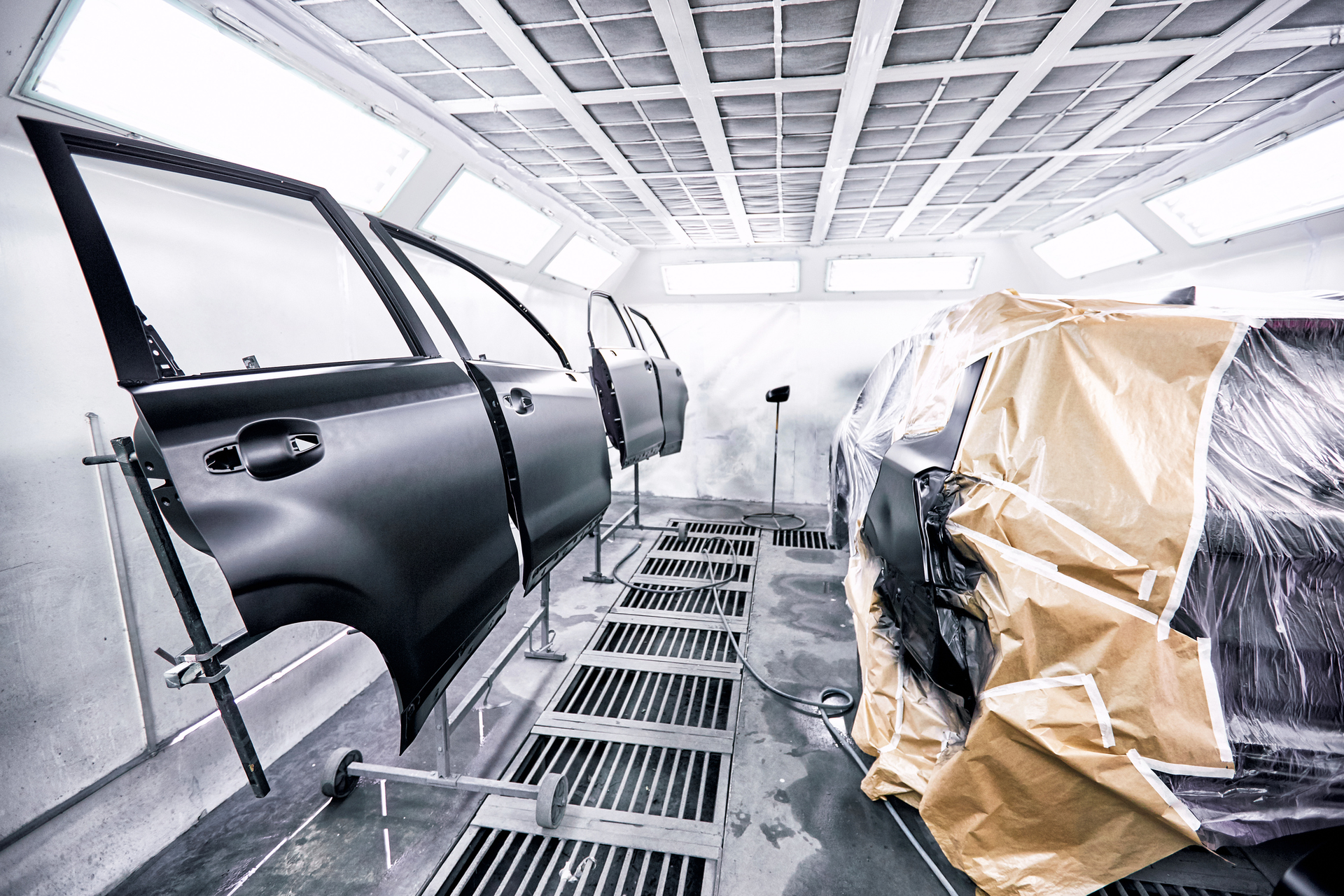 A car is being painted in a paint booth.