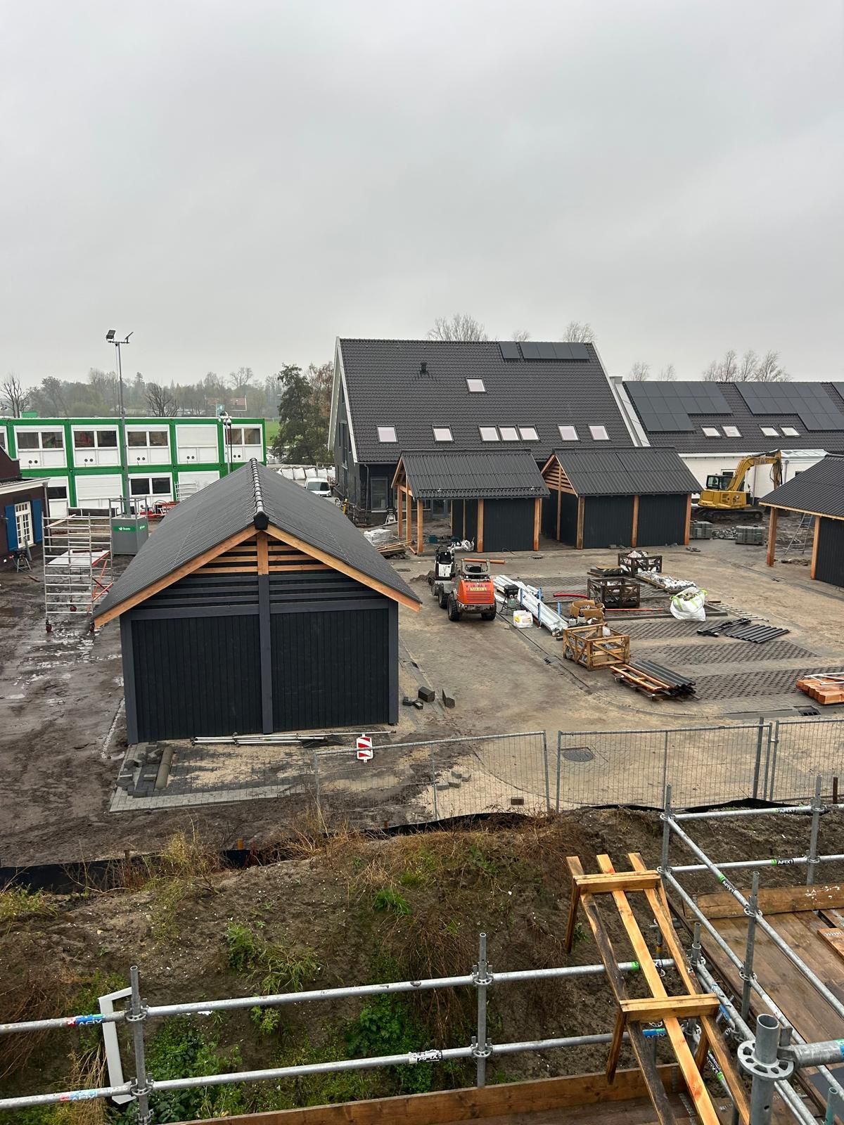 Een man is bezig met het bevestigen van houten planken op het dak van een moderne pergola. 