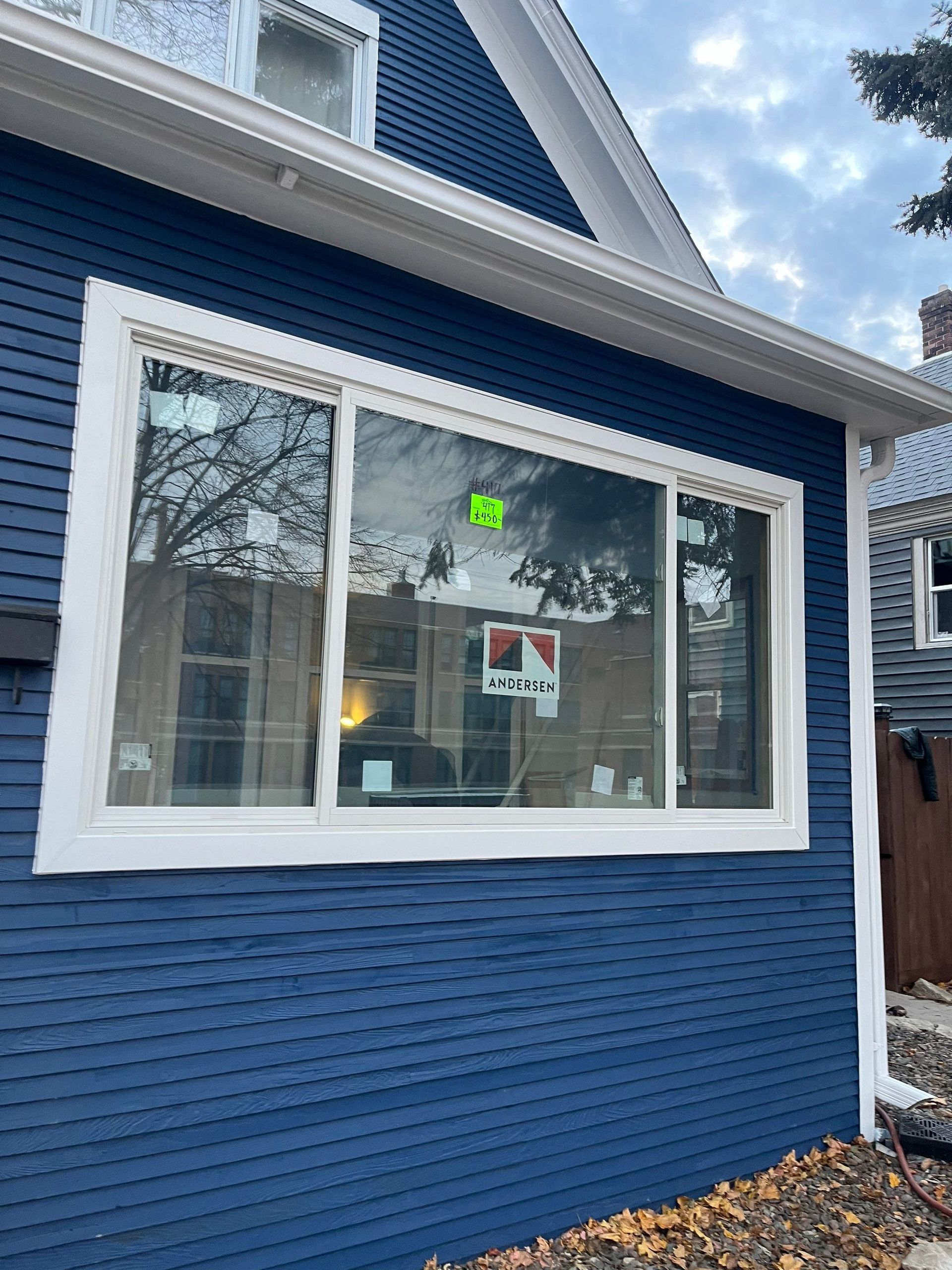Blue house with white trim and a large window.