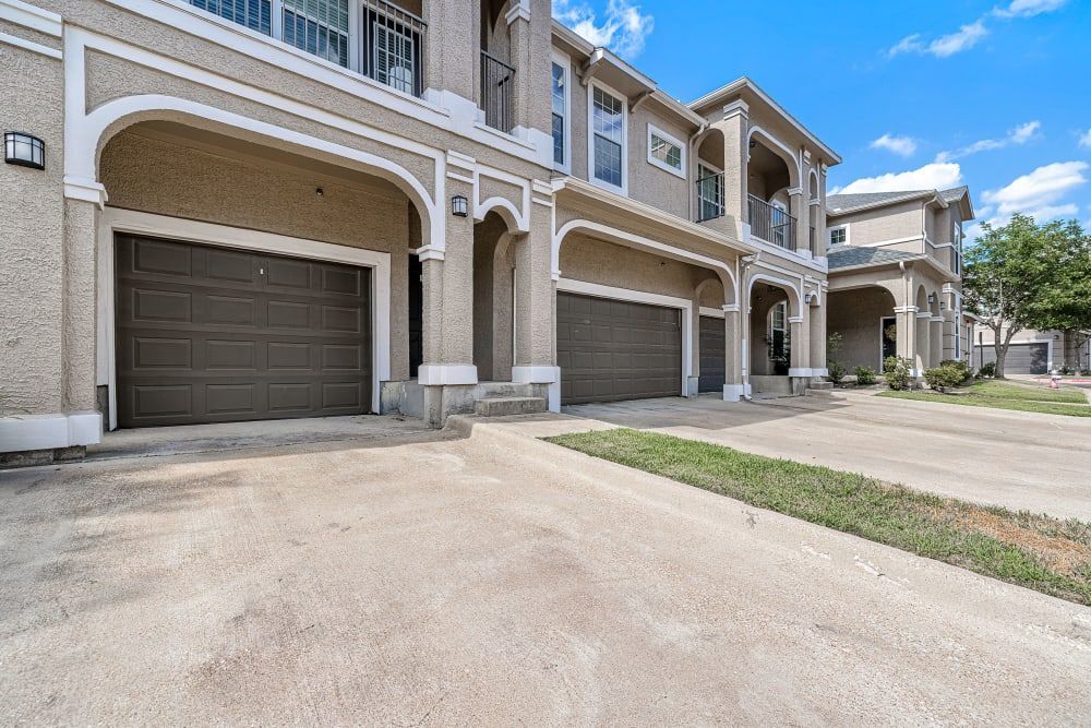 A row of apartment buildings with garages at Marquis at The Cascades in Tyler, TX.