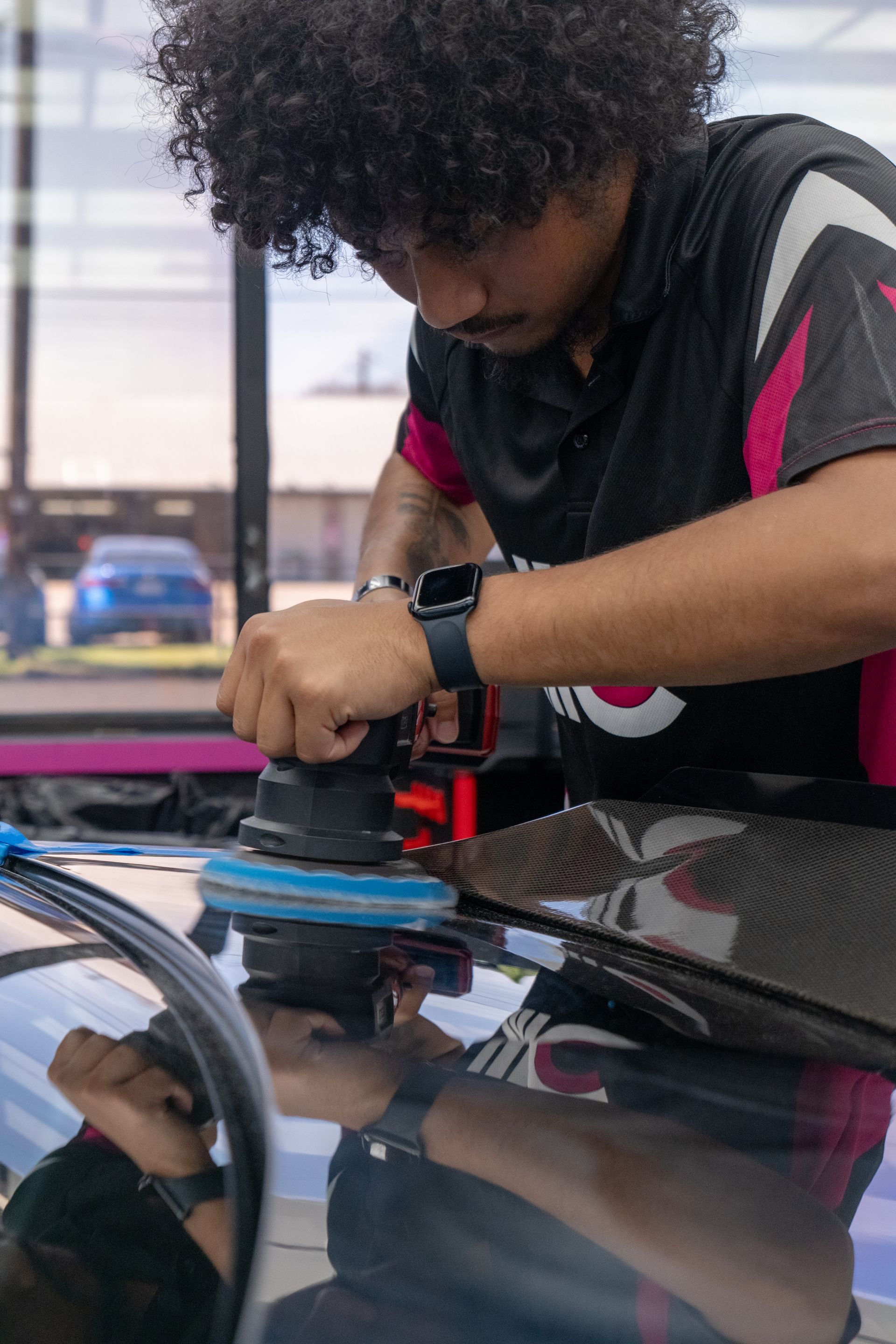 Technician performing paint correction on the carbon fiber hood of a Cadillac CTS-V using a dual action polisher near Temple, TX.