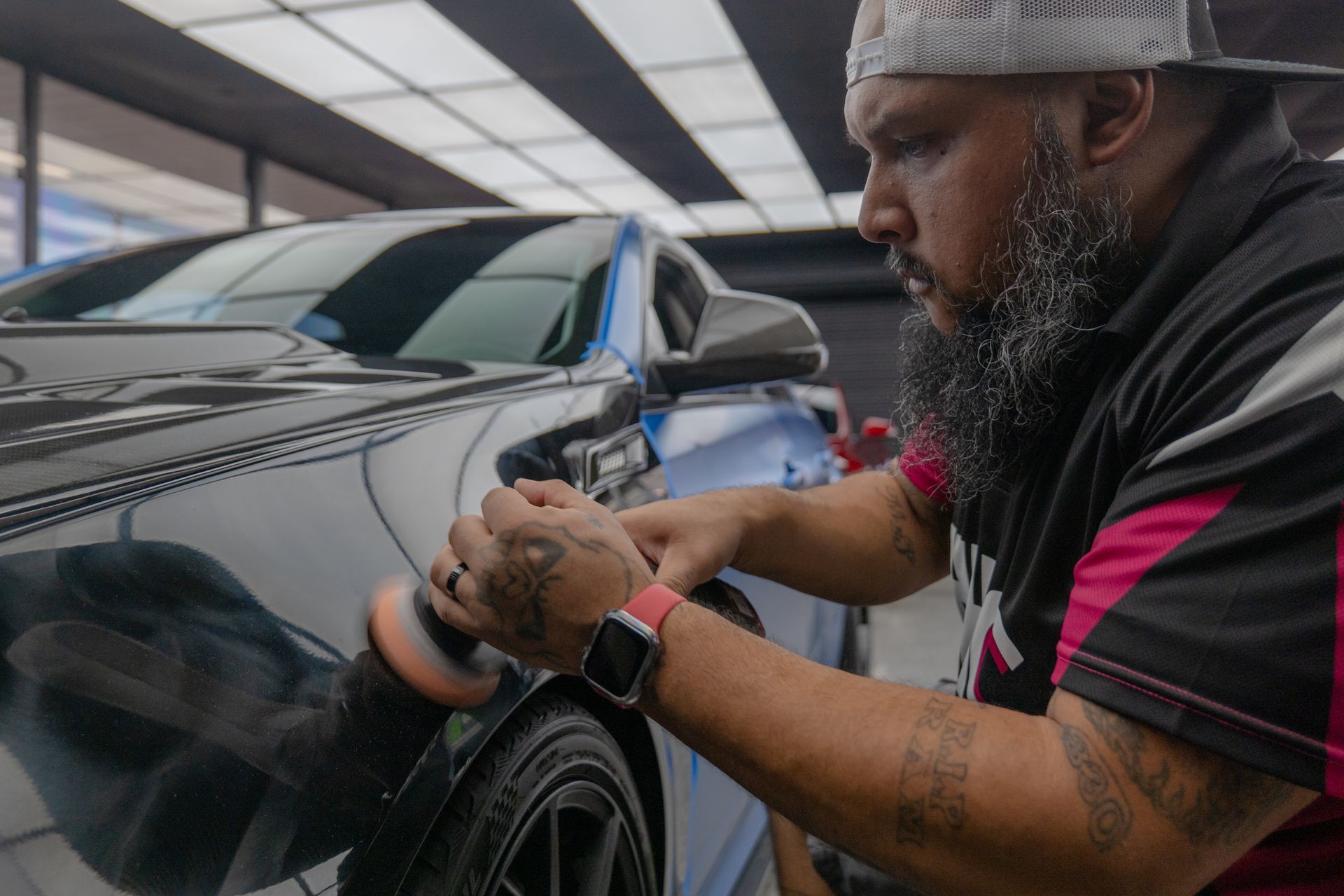 Technician polishing the front fender of a black 2011 Cadillac CTS-V during paint correction at Harker Heights Ceramic Coatings near Temple, TX.