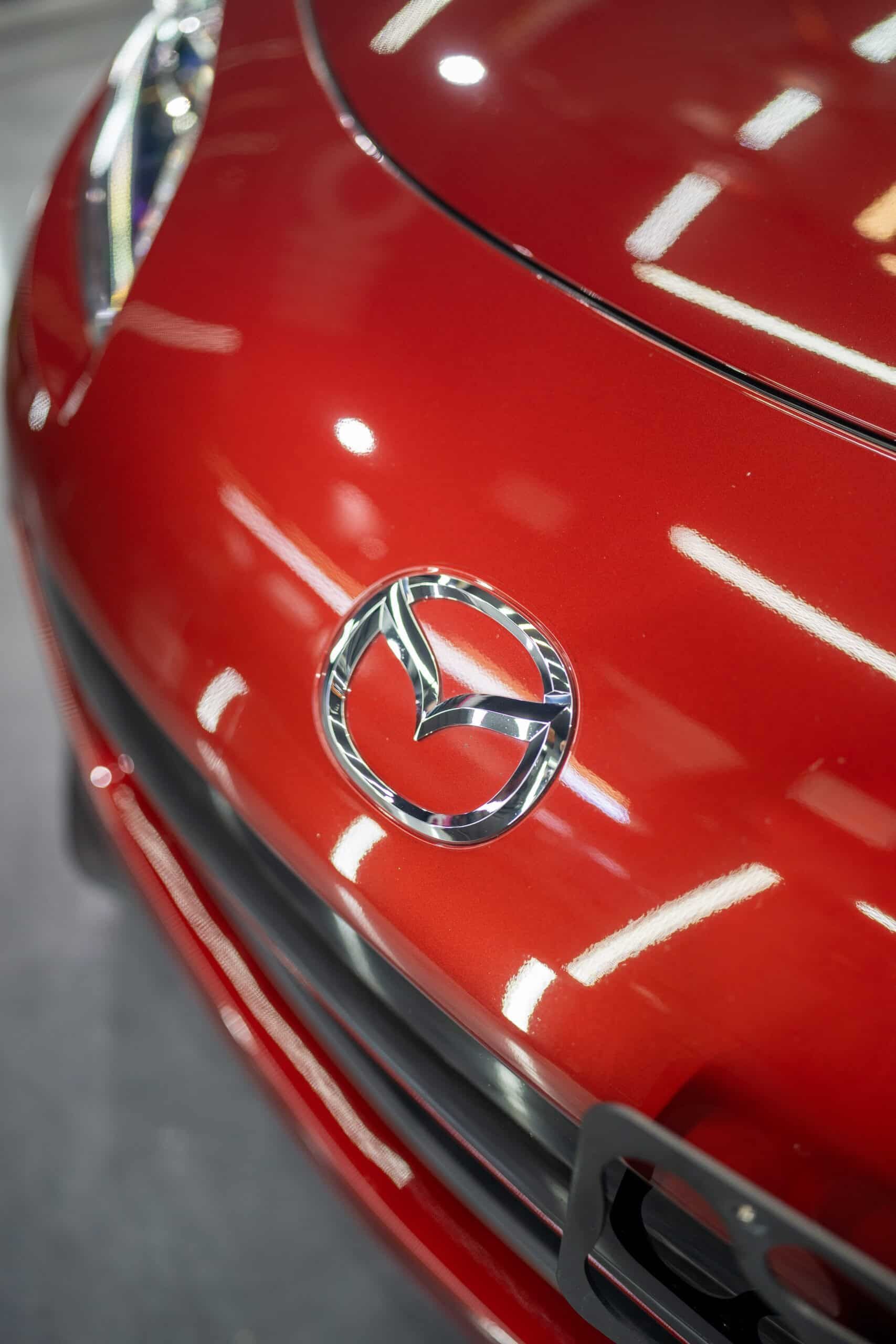A close up of the front of a red mazda car