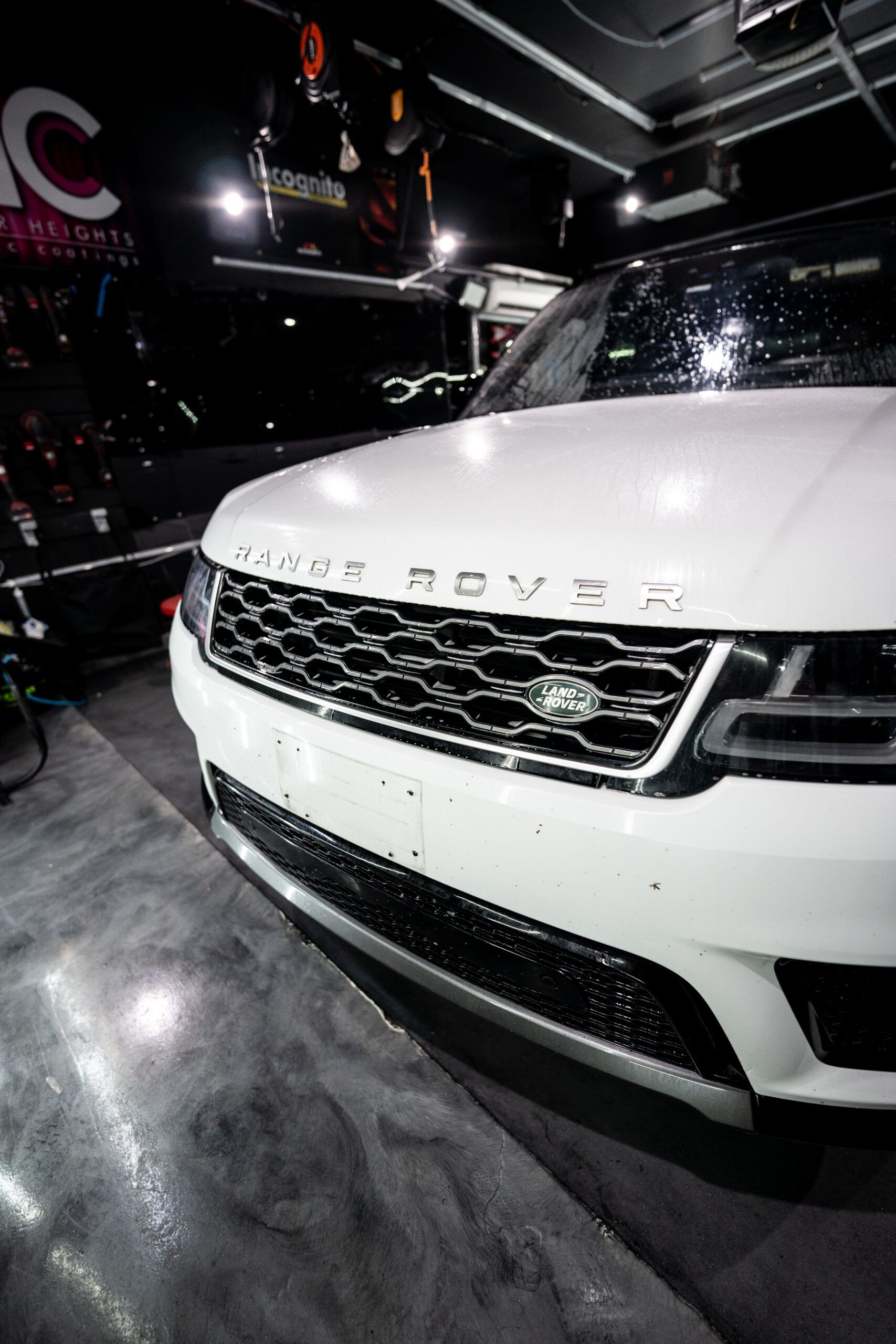 A white range rover is parked in a garage.