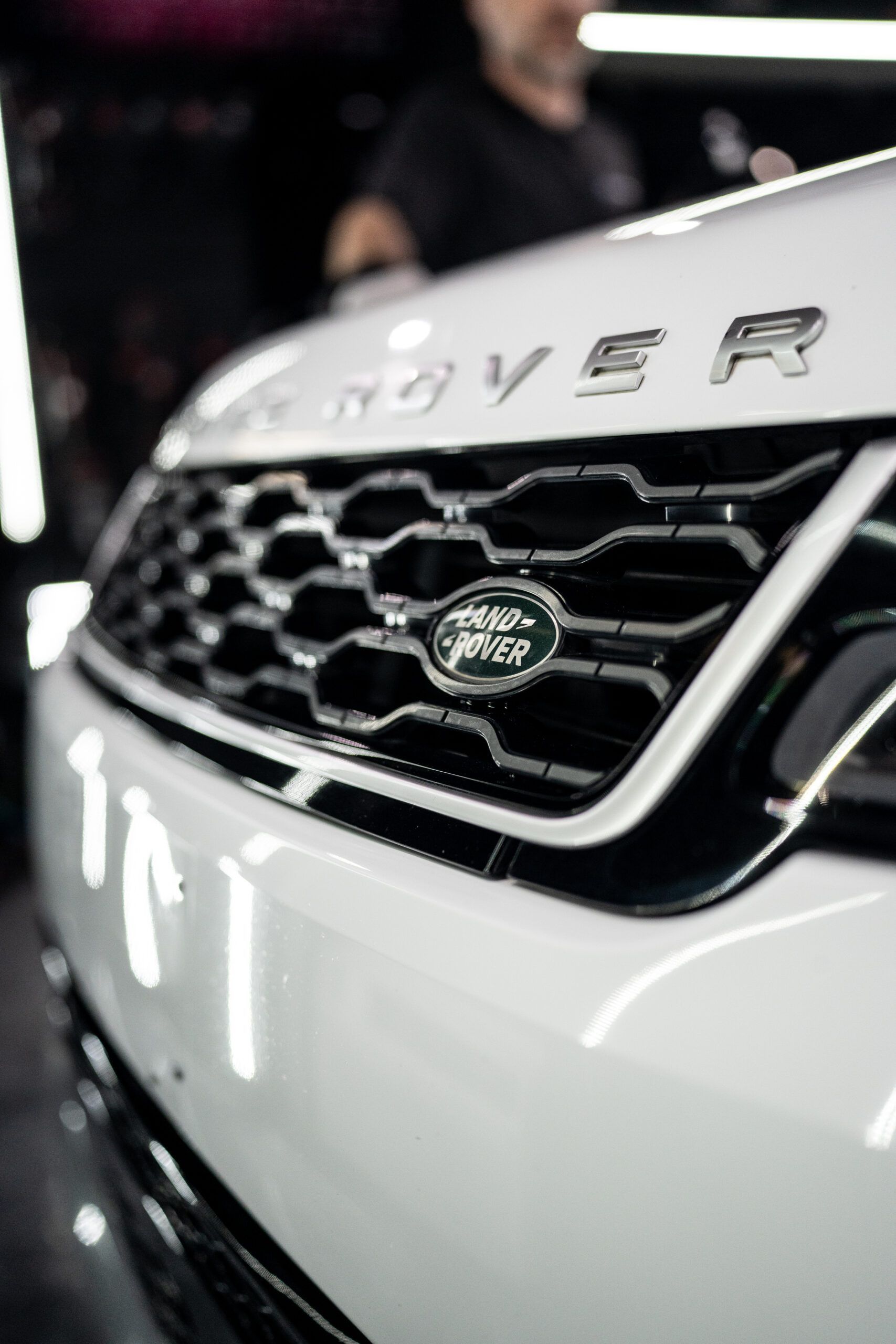 A close up of the front of a white range rover