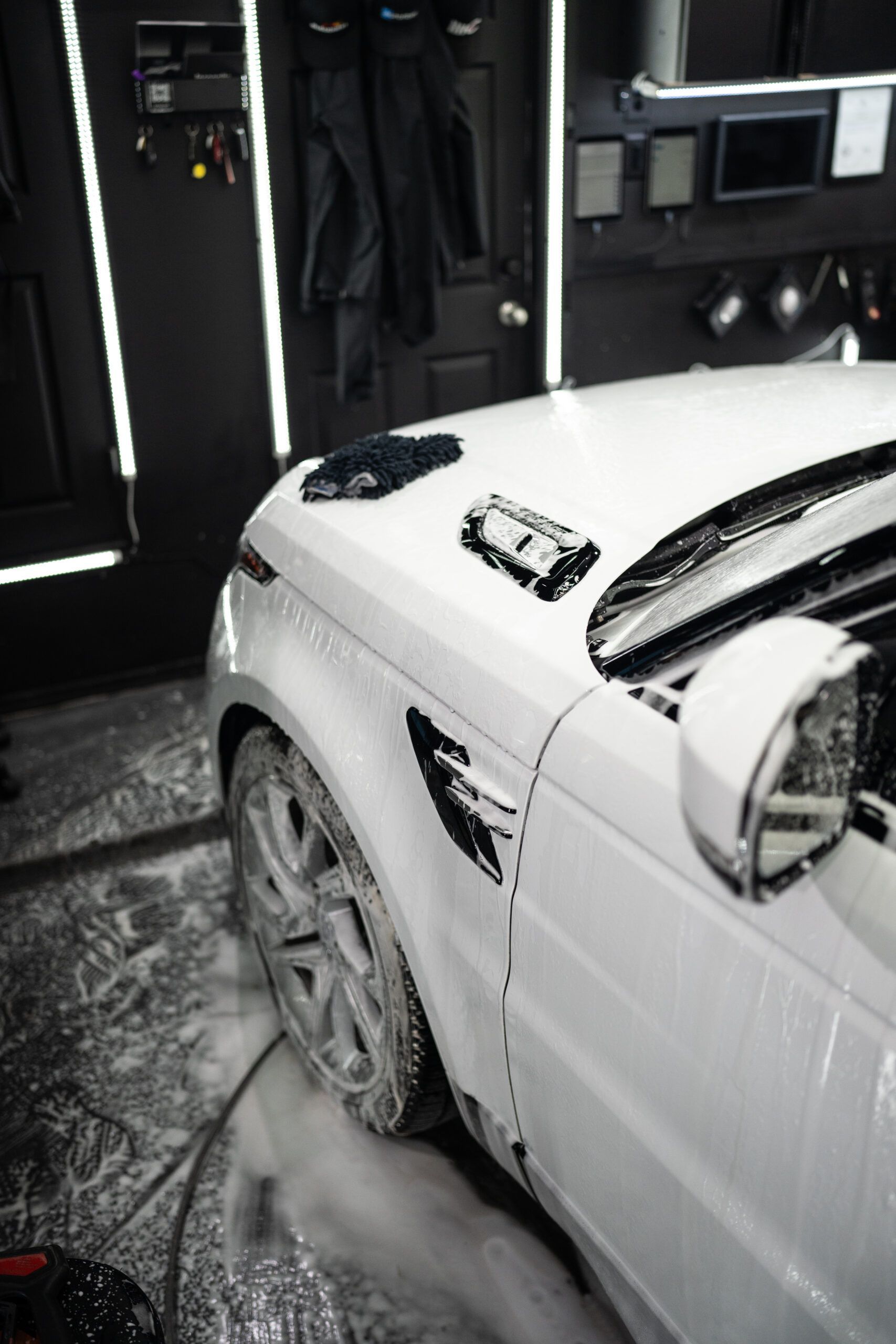 A white range rover is being washed in a garage.