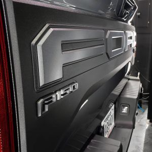 A close up of the back of a black ford f150 truck