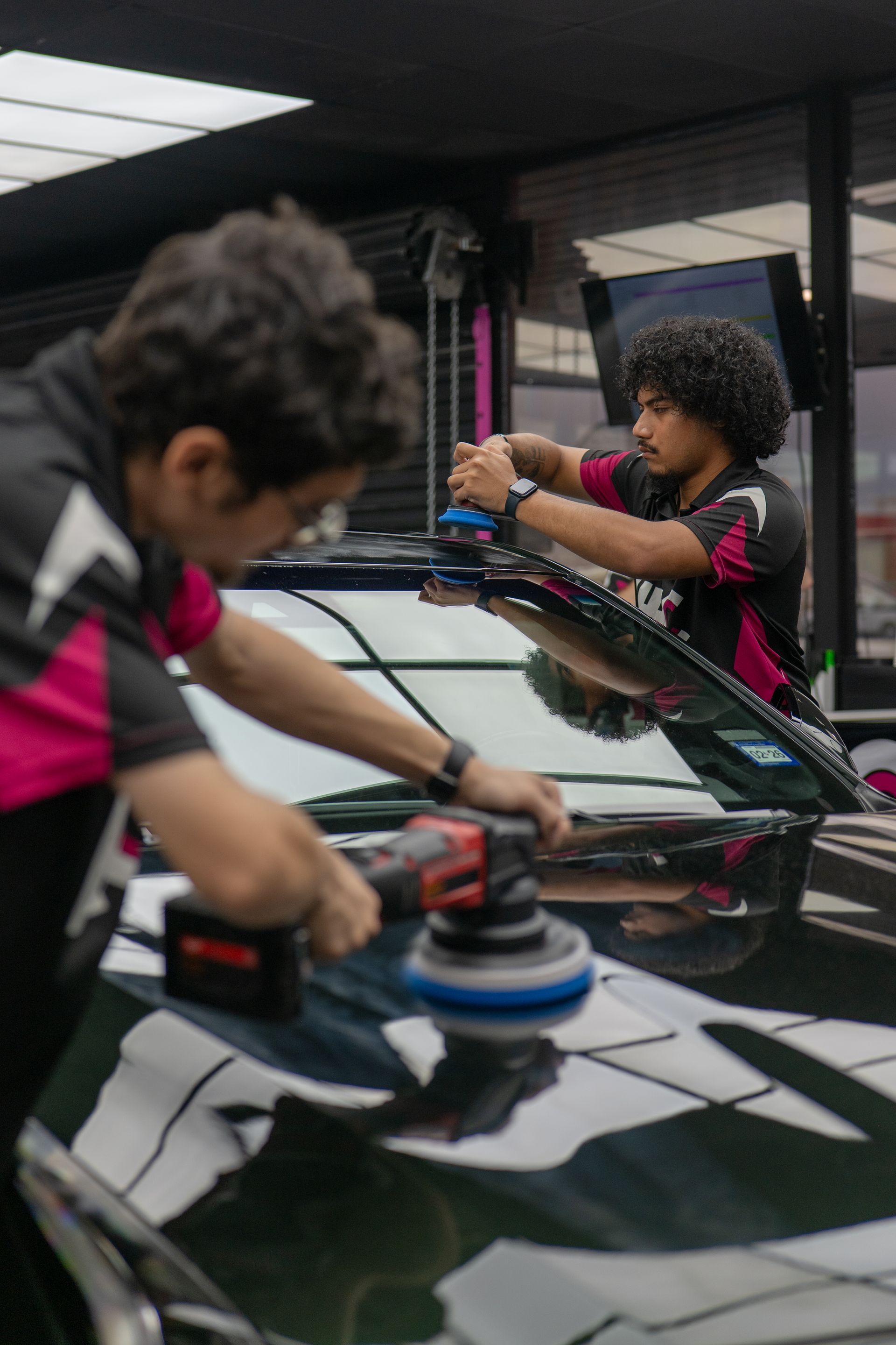 Detailers performing one-step paint correction on a green 2020 Cadillac CT5 using Flex and Milwaukee polishers at Harker Heights Ceramic Coatings near Killeen TX