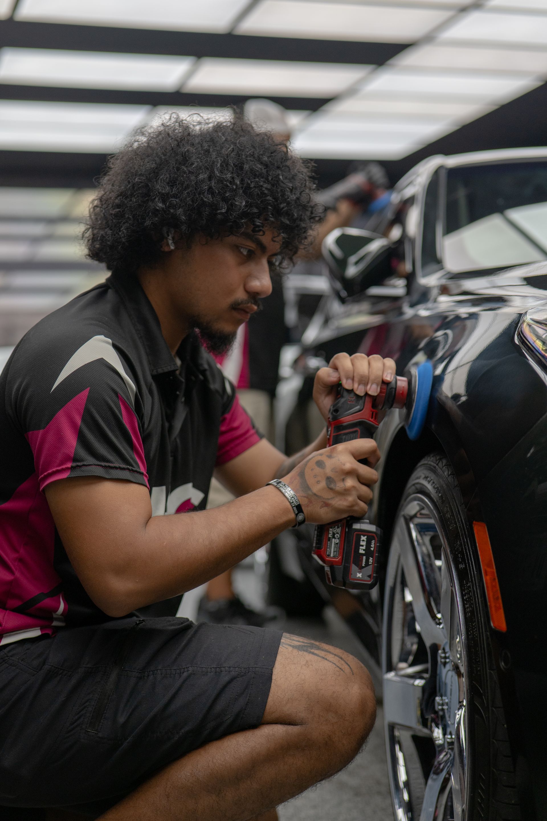 Detailer polishing Cadillac CT5 front fender during professional paint correction service near Killeen and Harker Heights TX