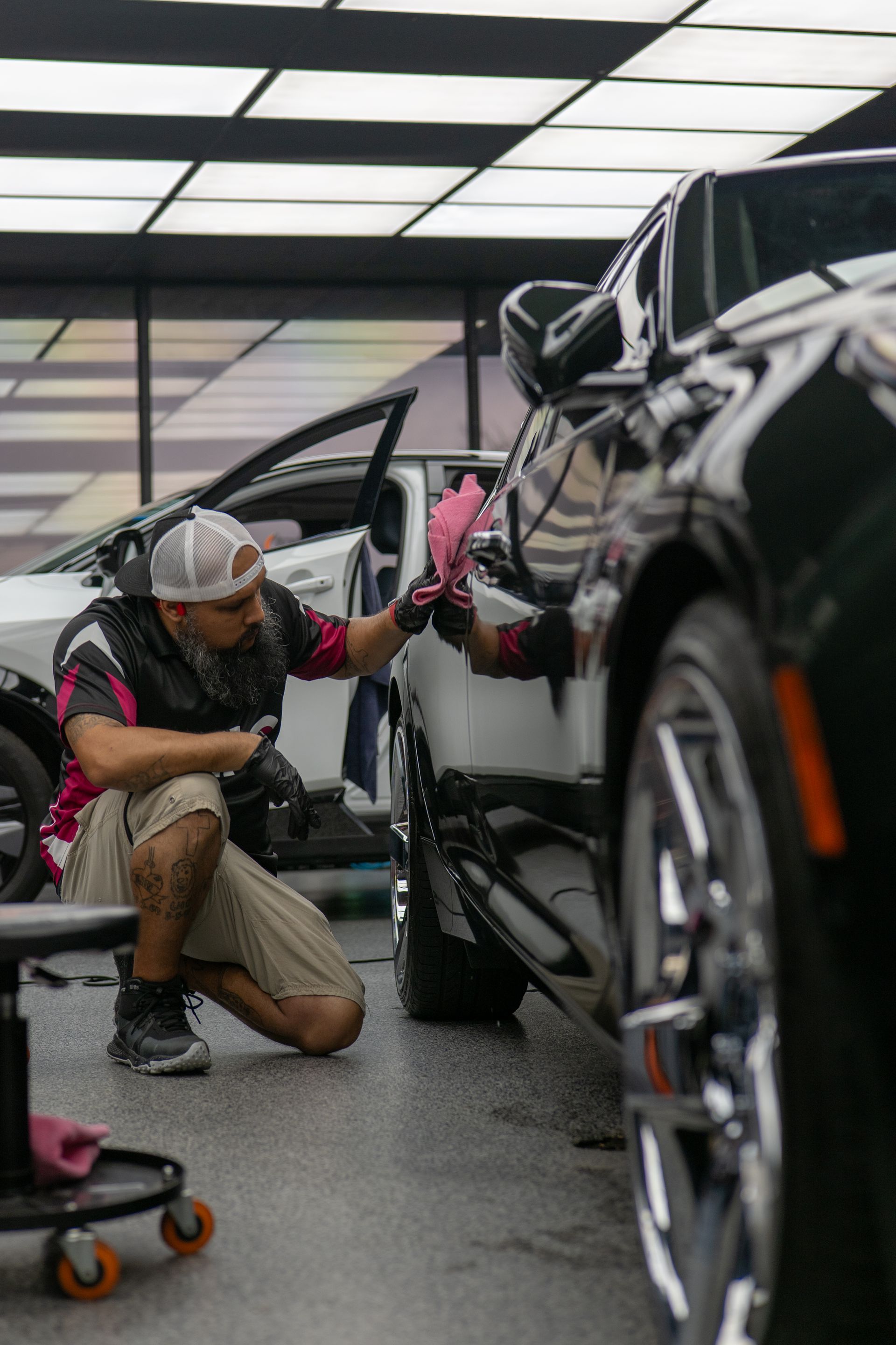 Auto detailer wiping polished paint on Cadillac CT5 before ceramic coating application near Killeen TX