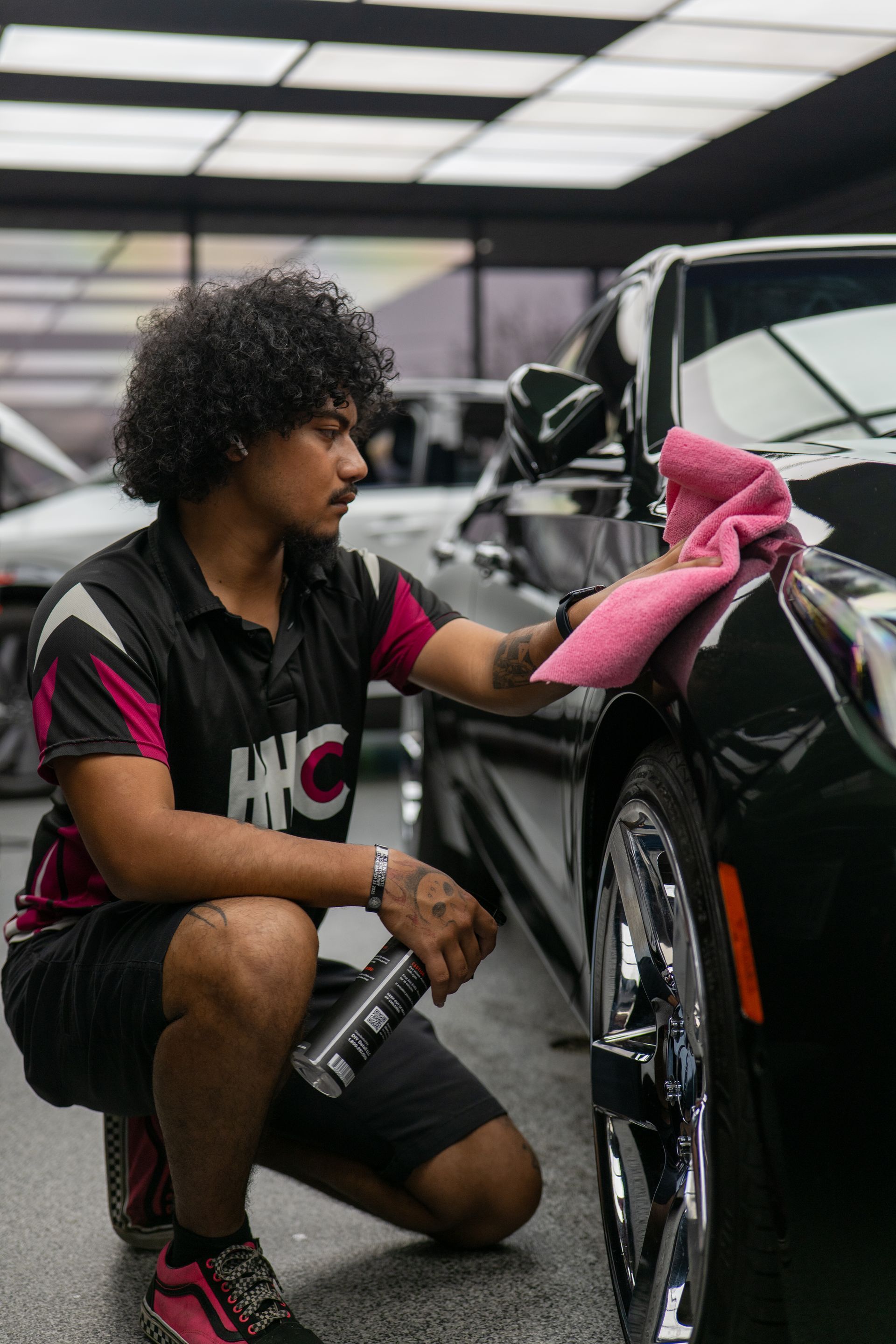 Detailer performing final wipe down before ceramic coating on green Cadillac CT5 at Harker Heights Ceramic Coatings near Killeen TX