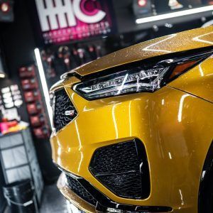 A close up of a yellow car in a garage.