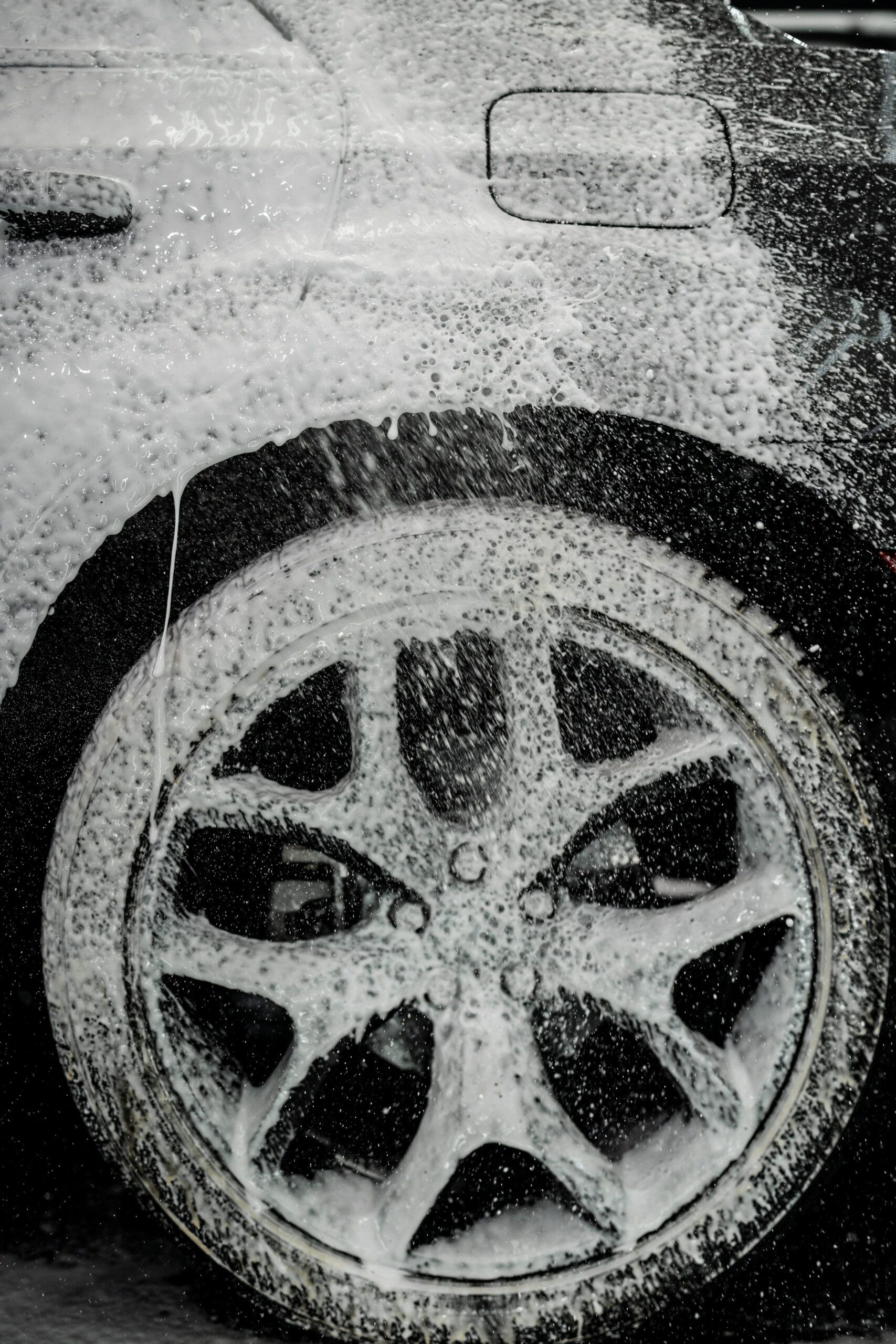 A black and white photo of a car wheel covered in foam.