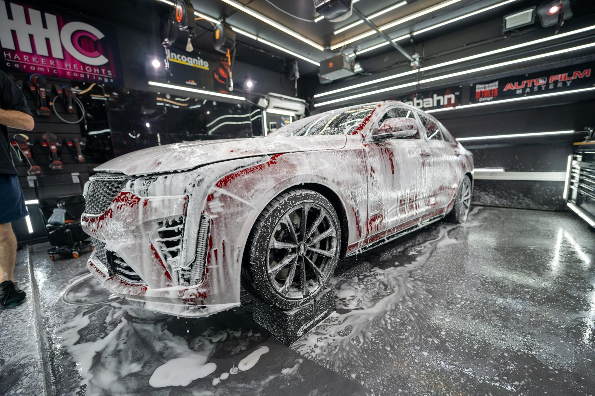 A car is covered in foam in a garage.