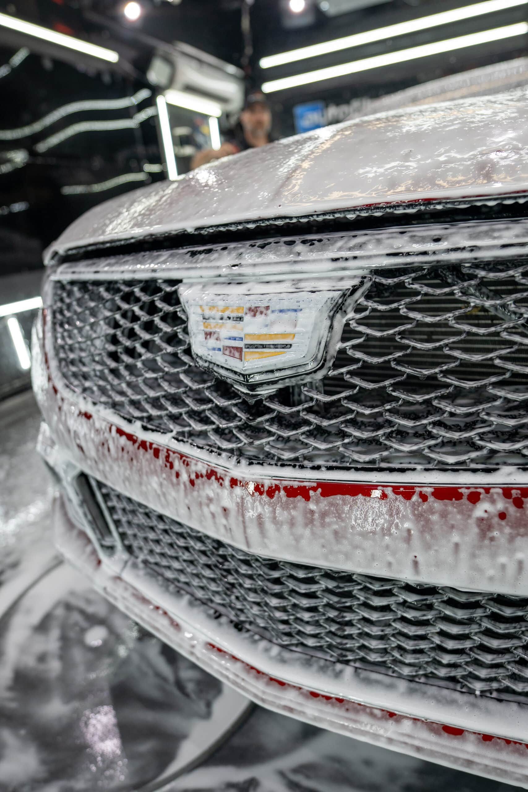 The front of a cadillac is covered in foam.