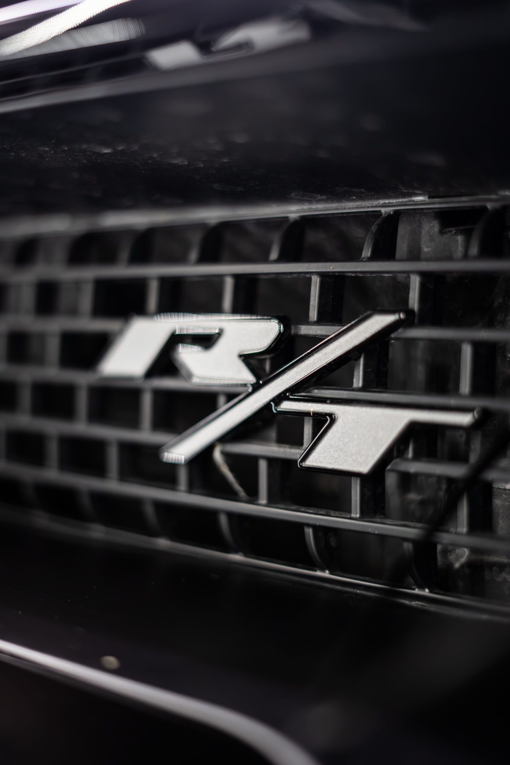 A close up of a car grille with the letters r and t on it.