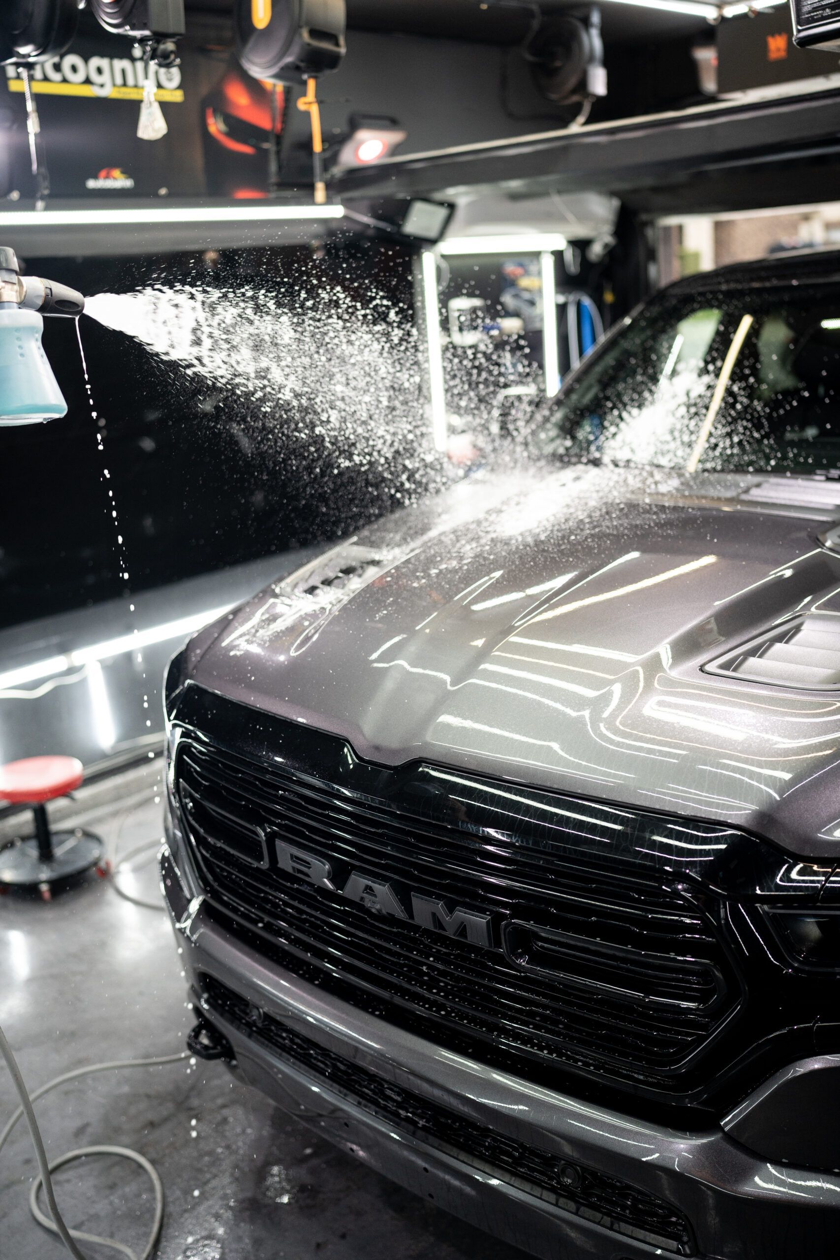 A gray ram truck is being washed in a garage.