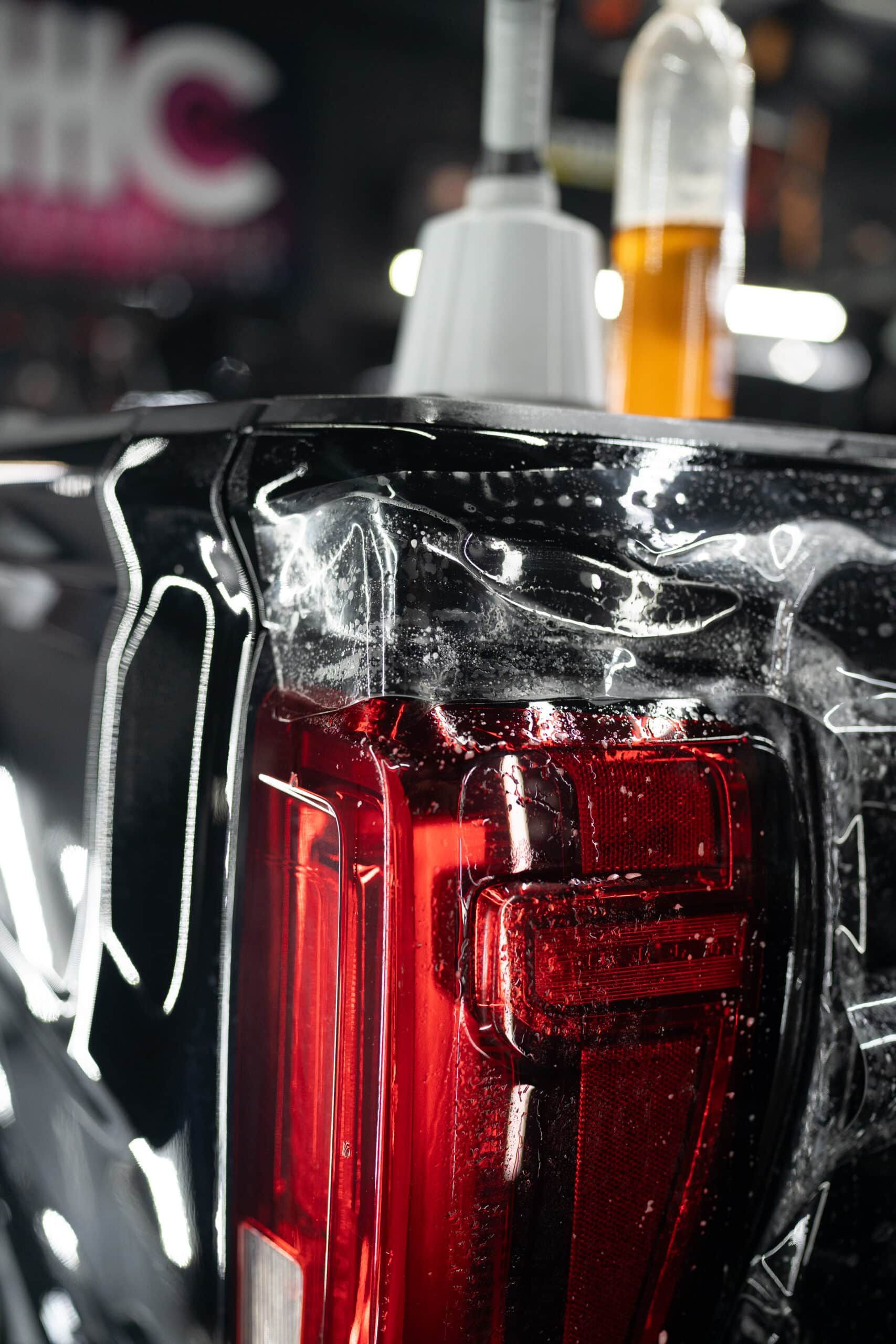 A close up of a red car tail light wrapped in plastic.