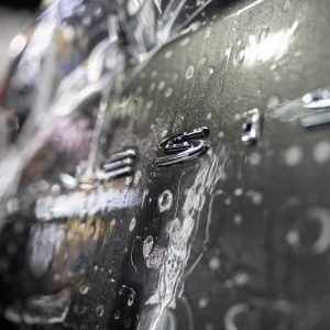 A close up of a car covered in plastic wrap.