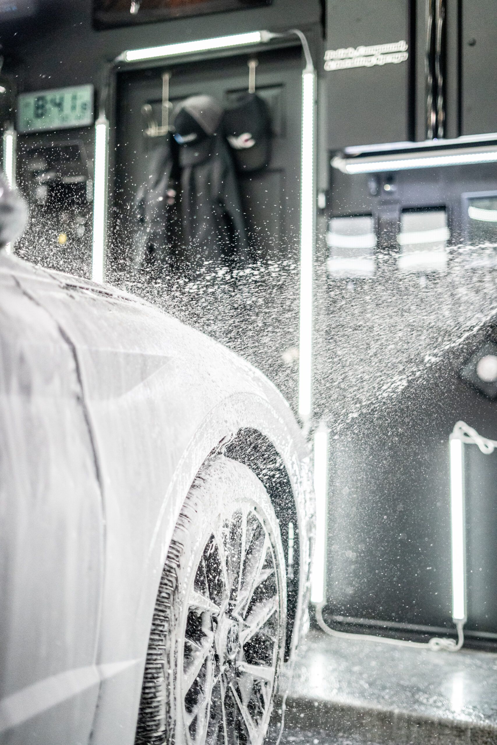 A car is being washed with foam in a car wash.