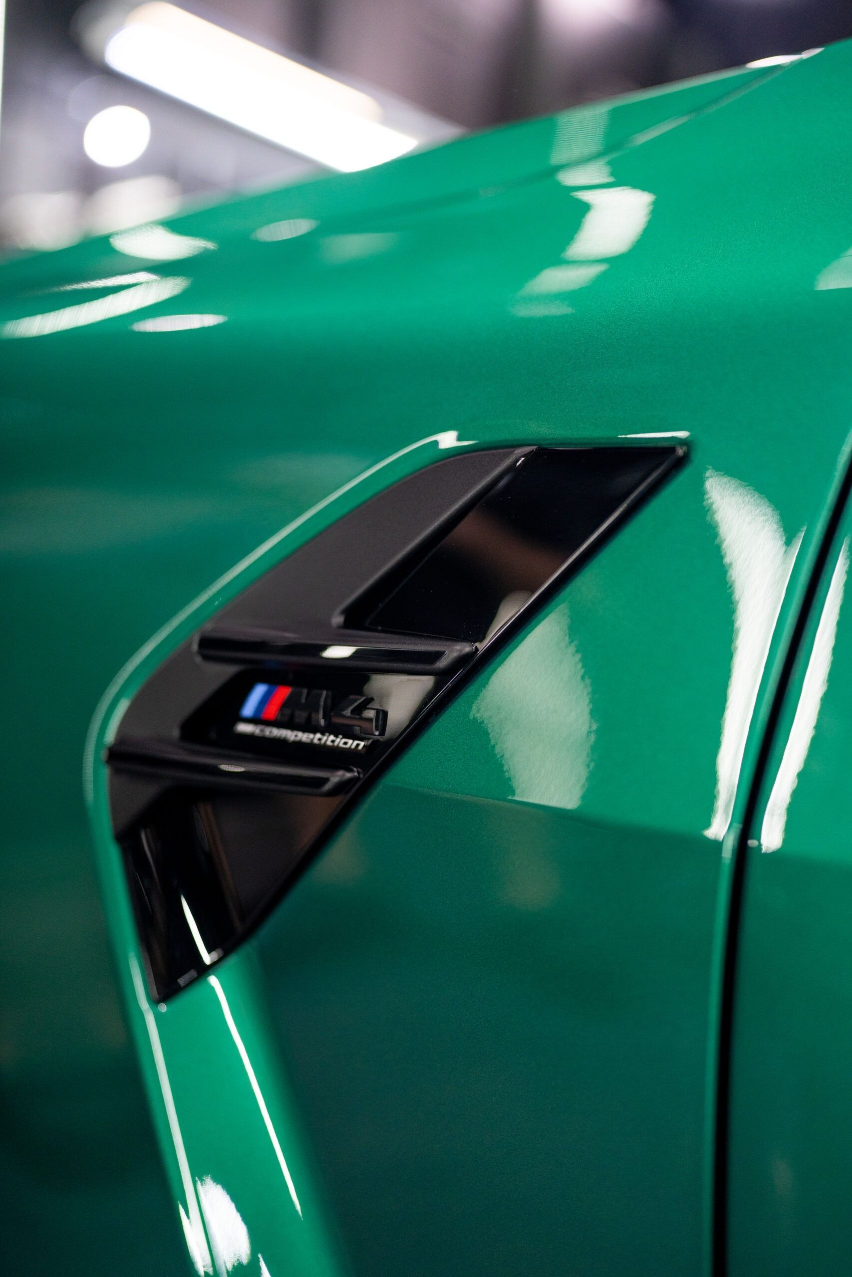 A close up of a green car with a black fender
