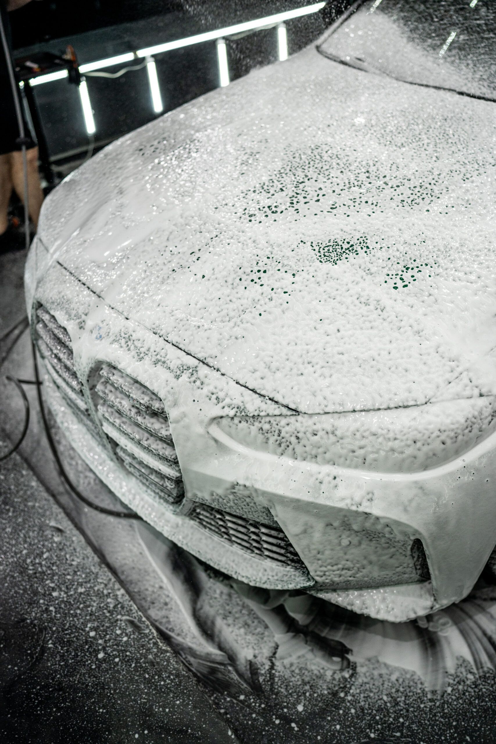 A black and white photo of a car covered in foam.