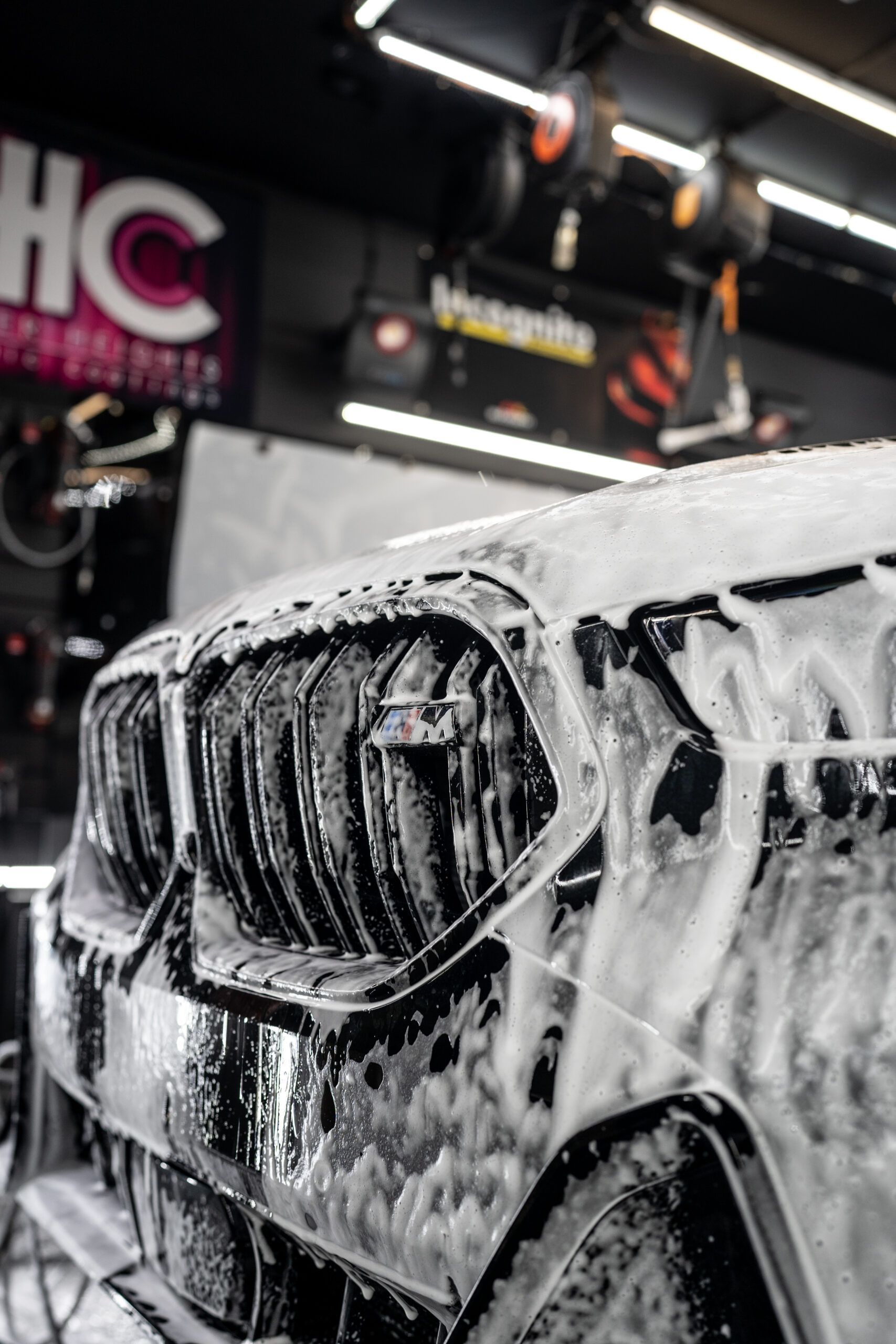 A car is covered in foam in a car wash.