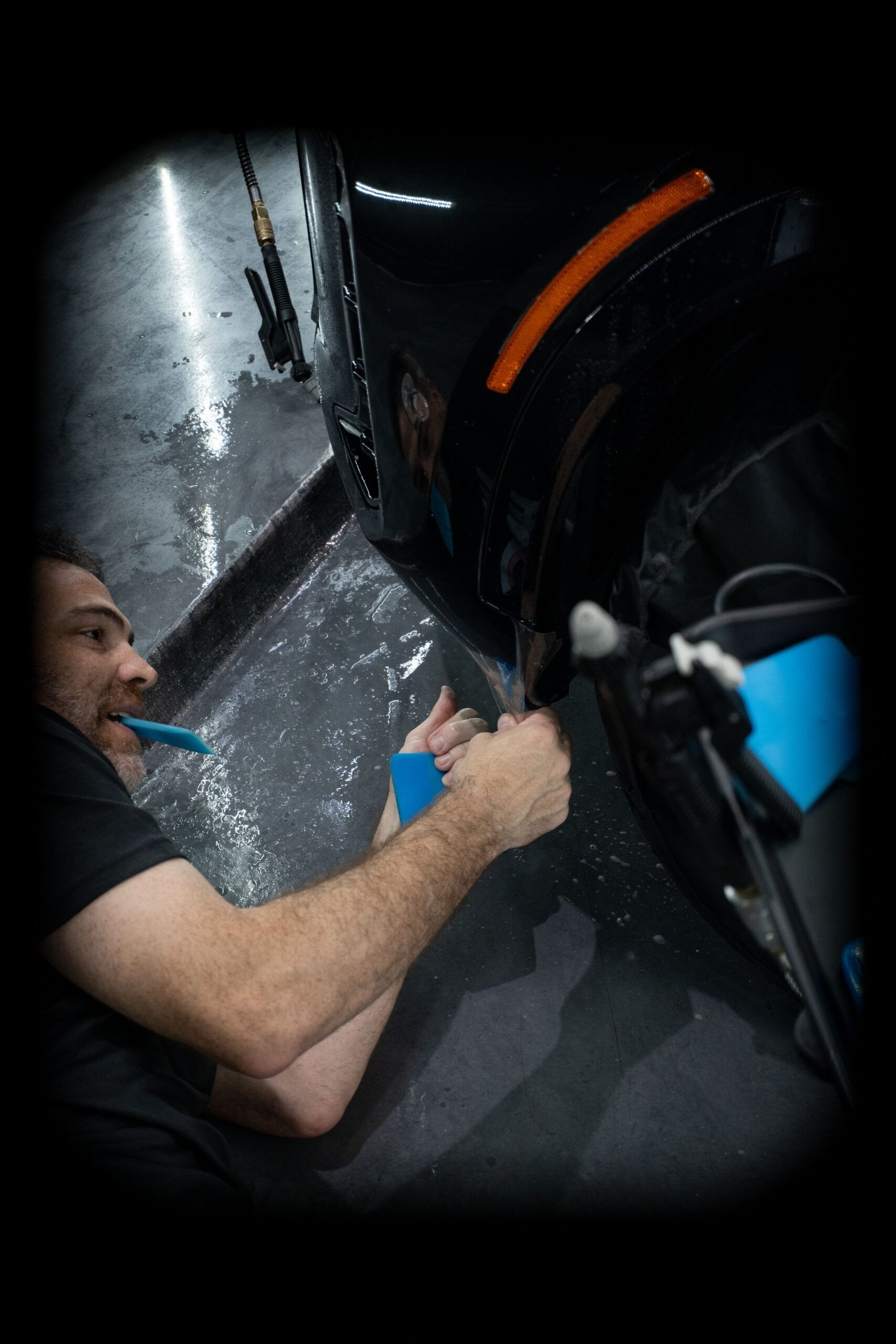 A man is cleaning a car with a brush.